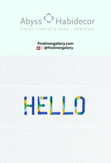 A plush Abyss Habidecor Hello Towel with bold "Hello" embroidery, soft cotton texture, and vibrant white and black design.