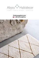 Soft beige Abyss Habidecor Heritage bath rug with textured woven design on a bathroom floor.